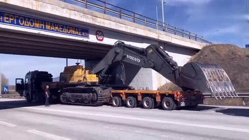 半掛車運輸挖掘機遇限高橋，老司機巧妙應(yīng)對顯功力